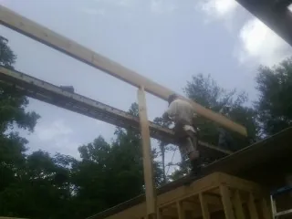 Carpenter setting a ridge beam over a new addition frame — Ice Dam Removal by Roofing Brothers in Royalton