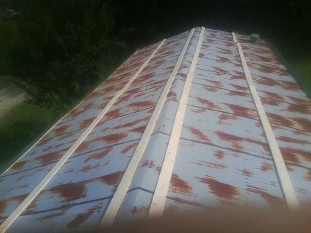 Rusted metal roof panels with new wood purlins before replacement — Storm Damage Roof Repair in Royalton by Roofing Brothers